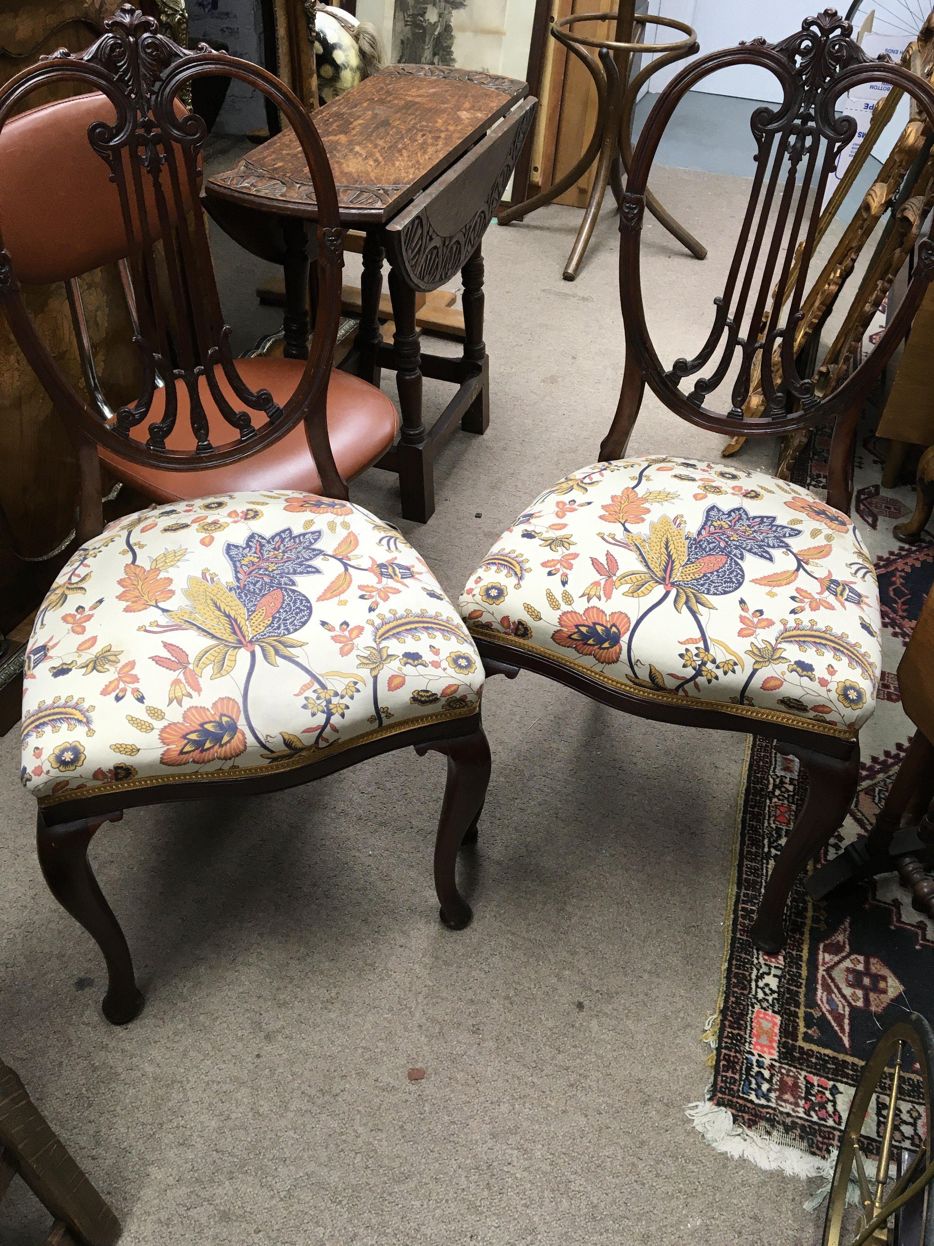 A pair of Edwardian walnut chairs with shaped open