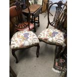 A pair of Edwardian walnut chairs with shaped open