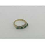 An 18ct gold ring set with 4 emeralds and 3 diamon
