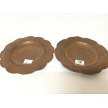 A pair of hand hammered copper Arts and Crafts dis