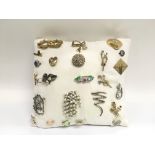 A collection of brooches presented on a cushion.