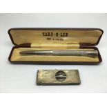 A silver cigar cutter and a cased pencil (2).