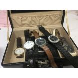 A black jewellery case containing gents watches in