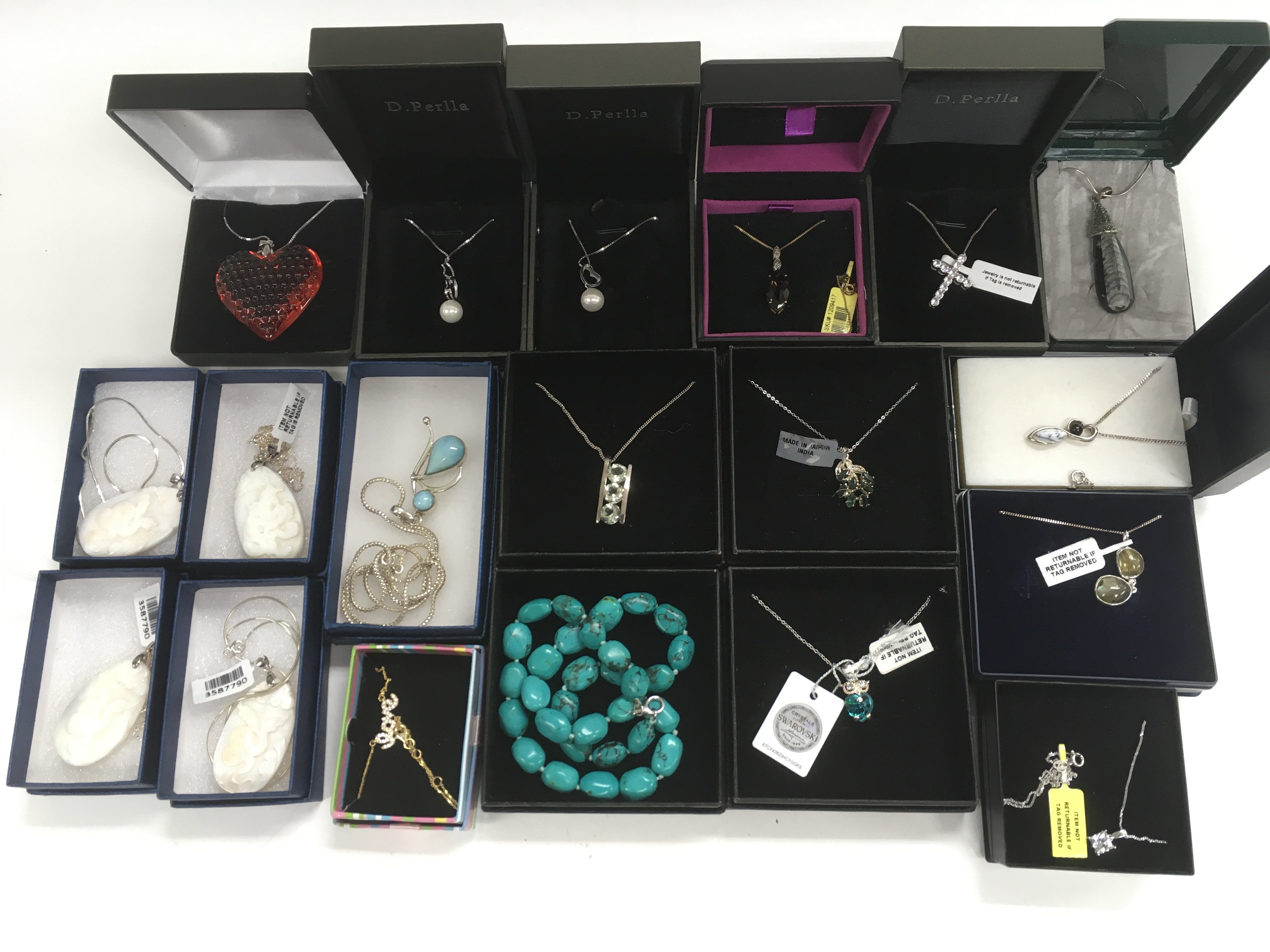 A collection of boxed silver pendants and chains.