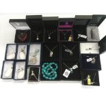 A collection of boxed silver pendants and chains.