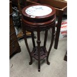 A carved hardwood oriental stand with a marble top