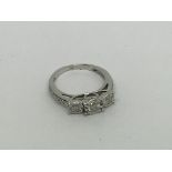 An 18ct white gold ring set with 3 diamonds and di