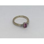 An 18ct gold ring set with a pink sapphire and 2 d