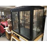 A dark stained oak shop display cabinet with glazed doors. 91x59cm