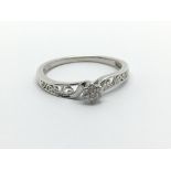 A silver ring set with seven small diamonds, approx 2g and approx size R-S.