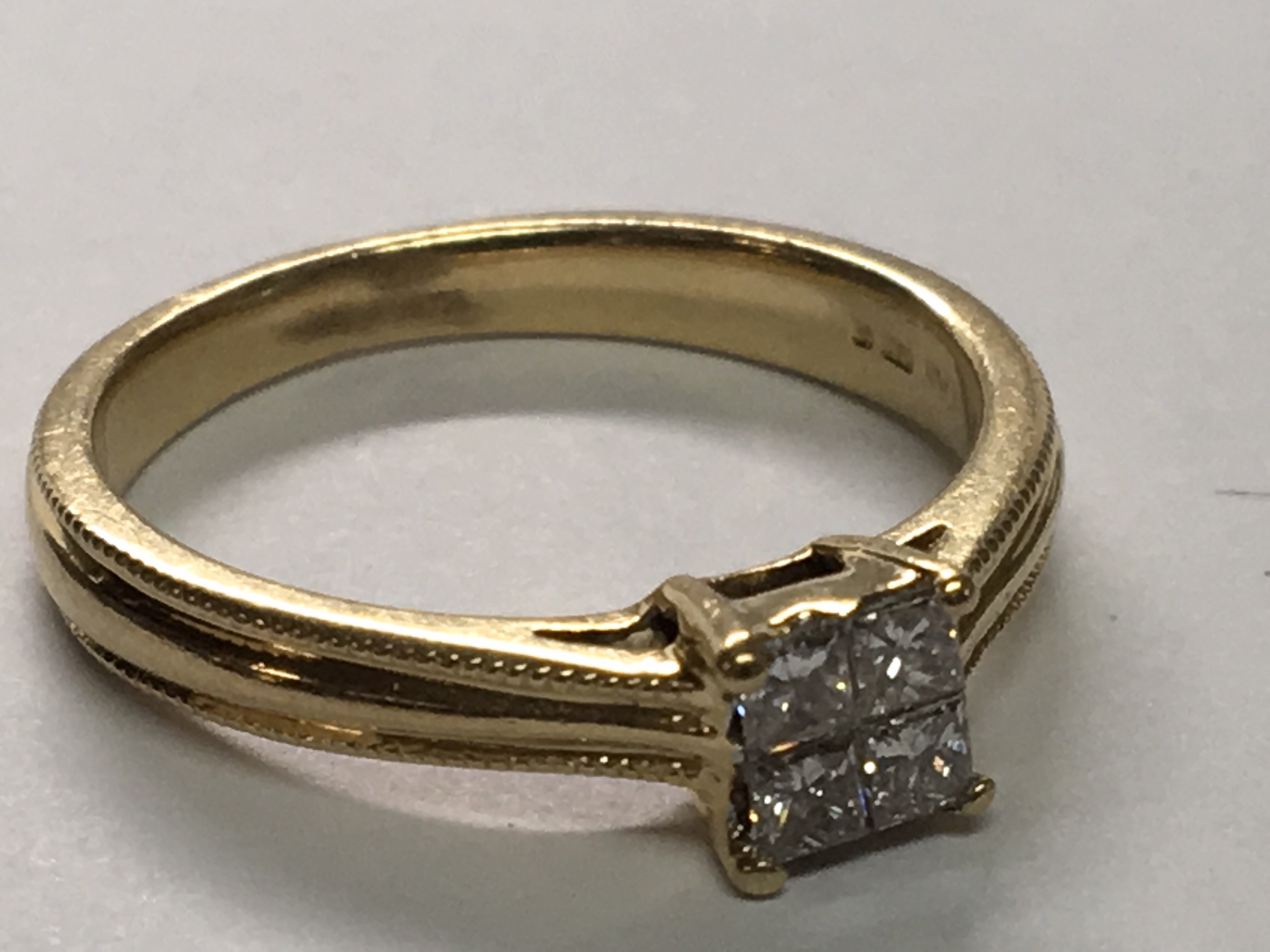 An 18carat gold ring set with a square pattern of Princess cut diamonds approximately 0.25 of a