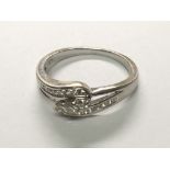 An 18carat white gold ring set with intertwined rows of brilliant cut diamonds with three central