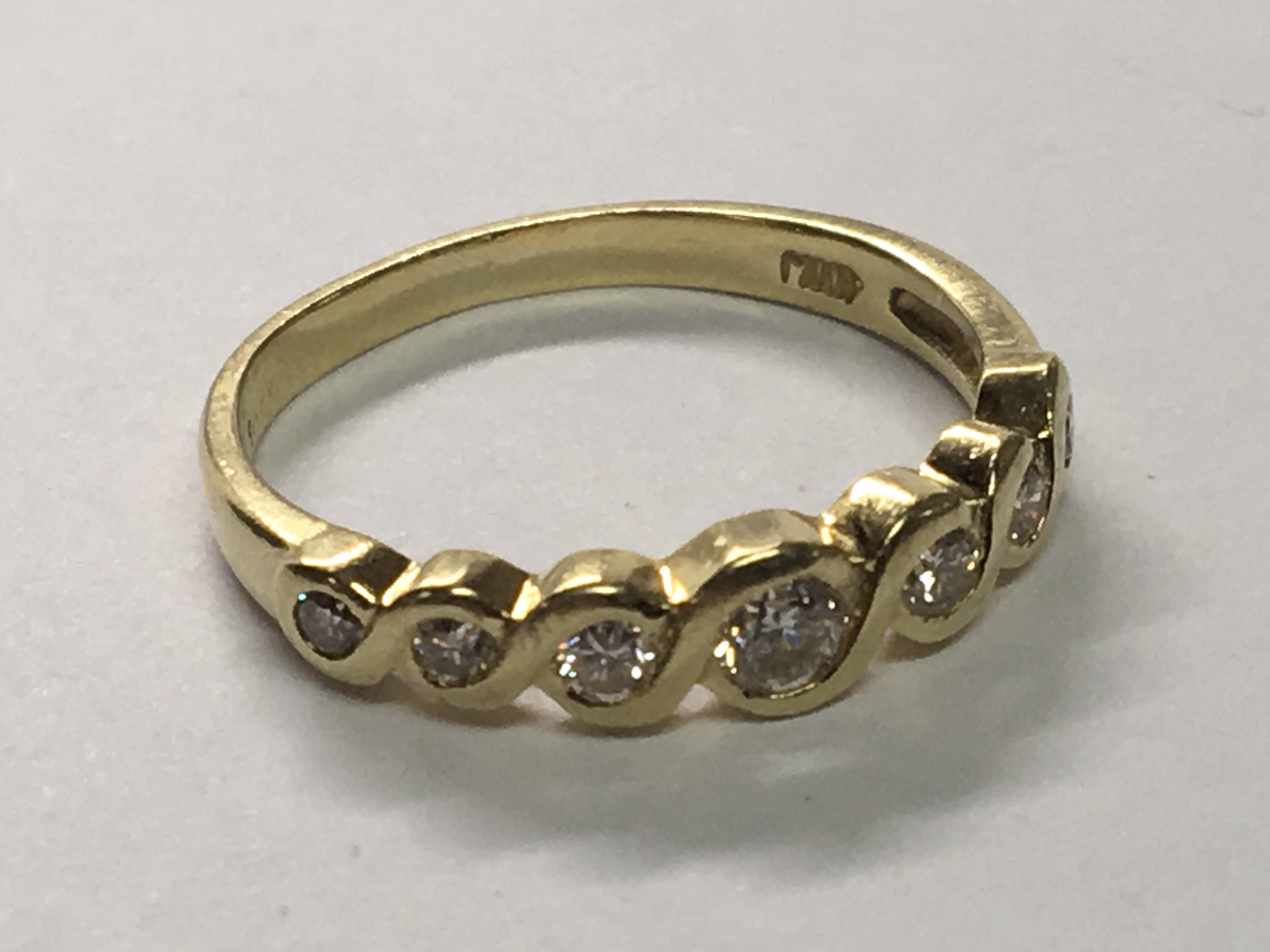 An 18carat yellow gold ring set with eight diamonds with a woven effect shank. Ring size L.