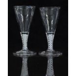 A pair of 18thC ale glasses with white double twist stems and conical shaped bowls raised on conical