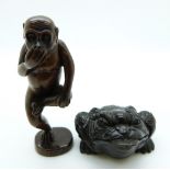 Japanese dark wood netsuke depicting a monkey standing on one leg, together with a dark wood netsuke