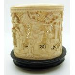 A 19thC carved Chinese ivory pot depicting figures on hardwood stand, 6.5cm