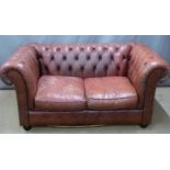 A red leather two seat Chesterfield sofa, W152 x D82 x H76cm