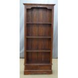 A stained pine bookcase over two drawers, W76 x D28 x H178cm