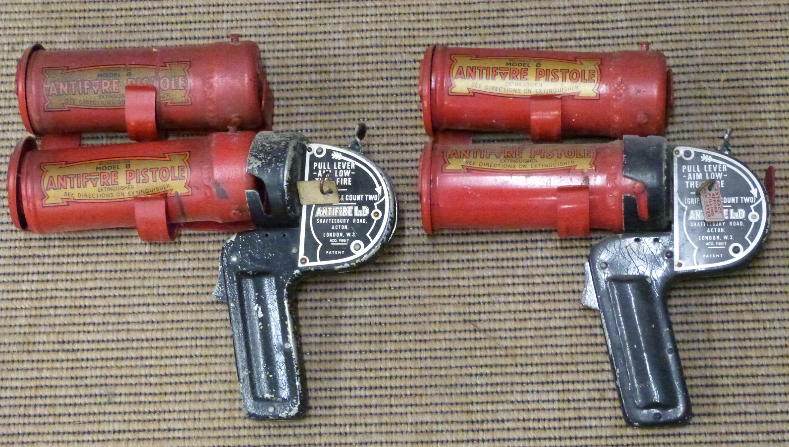 Four 'AntiFyre' model B Fire pistol extinguishers, two with trigger attachments, with wall brackets