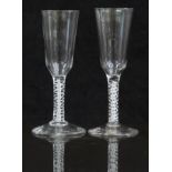 A pair of 18thC drinking glasses both with white double twist stems and long ogee shaped bowls