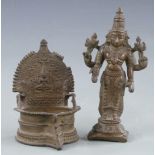 Two Eastern bronzes, one a deity the other a water vessel or font in the form of a chair, largest