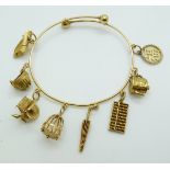 Chinese 20k gold bangle with eight 20k gold charms by Luen Wo including a teapot, abacus, parasol,