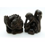 Japanese dark wood netsuke depicting a large monkey climbing rocks and a dark wood netsuke depicting