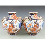 A pair of Japanese Imari bulbous vases with ring handles decorated with figural scenes, 31cm tall