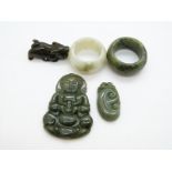 Two jadeite archer's rings, two jadeite pendants and a small jadeite carving