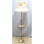 A brass adjustable standard lamp with shelf raised on pad feet, H170cm