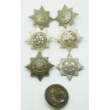 Seven British Army 4th/7th Dragoon Guards metal collar badges including a silver voided example.