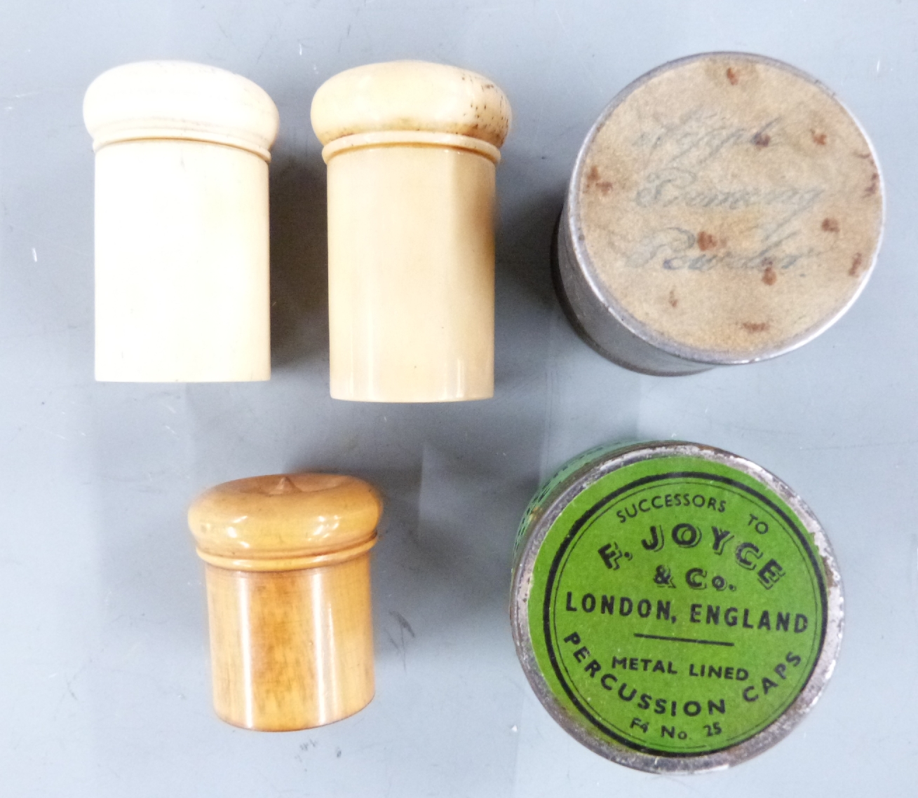 Five various percussion cap tins comprising a turned bone pair, a ...