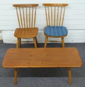 Two Ercol style light elm dining chairs and an Ercol style light elm coffee table