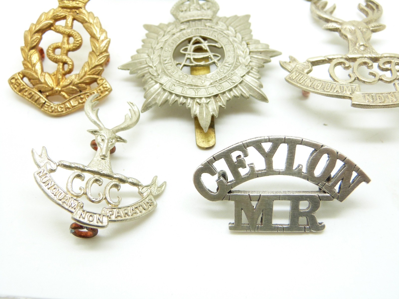 Seven Ceylon metal military badges including Cadet Corps, Military ...