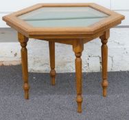 Hexagonal glass topped display cabinet or table with felt interior raised on four reeded legs, 50