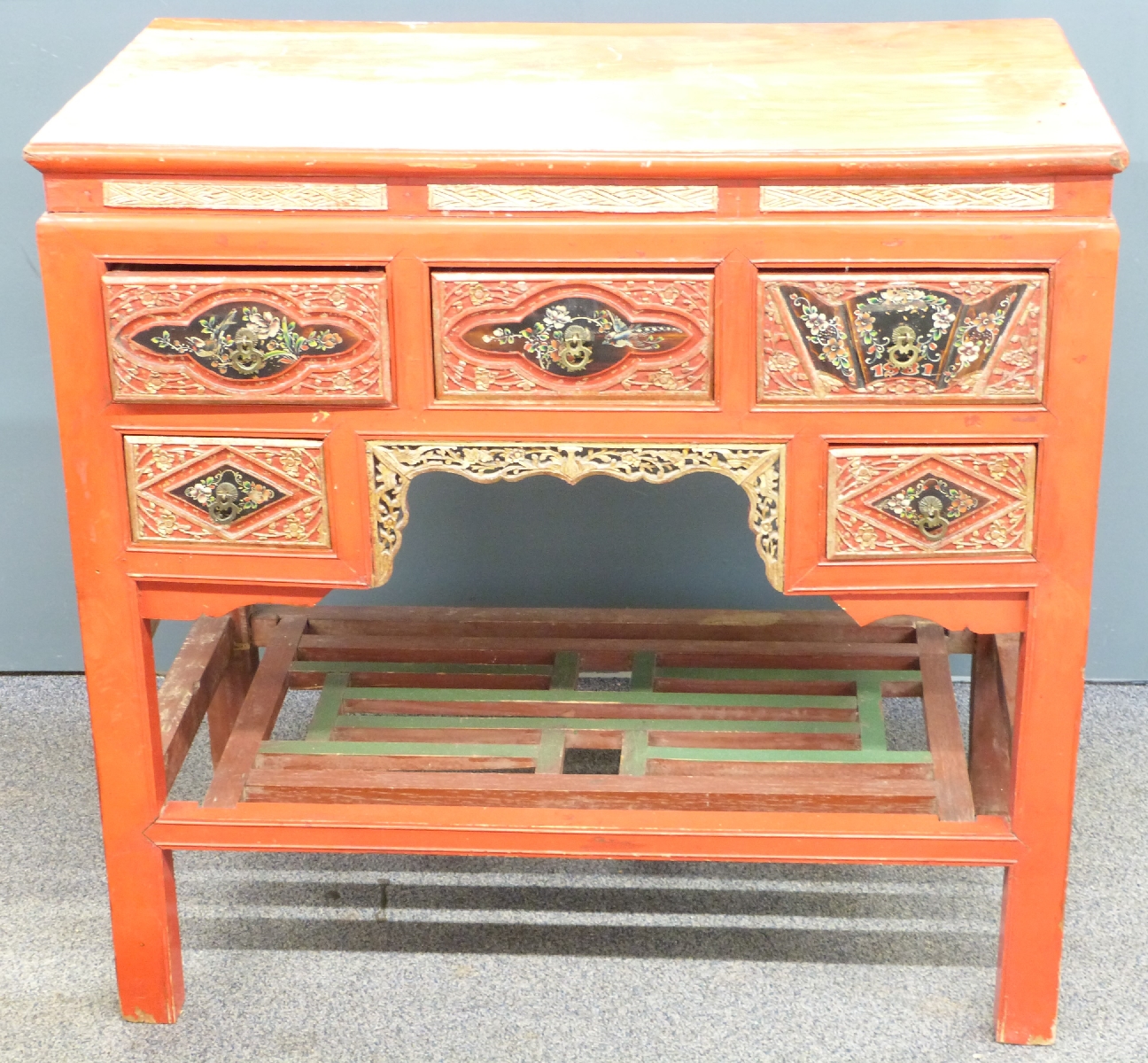 Oriental red lacquer desk with carved and pierced decoration highlighted in gilt and painted