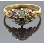 An early Victorian ring set with emeralds and diamonds, with scrolling shoulders and to the