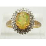 A 9ct gold ring set with an oval cut Indonesian opal surrounded by zircons, 2.3g, size S