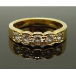 An 18ct gold ring set with five round cut cubic zirconia, size P, 6.18g