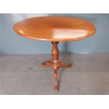 Mahogany oval tilt topped table raised on turned stem and tripod base, W79 x D47 x H70cm