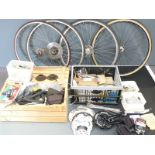 Large collection of bicycle components including four rear wheels, chain sets, Shimano derailleur