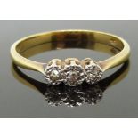 An 18ct gold ring set with three diamonds in a platinum setting, 2.20g