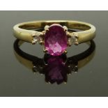A 9ct gold ring set with an oval rubellite and two diamonds, size M, 2.42g