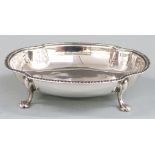 George V hallmarked silver trinket or bon bon dish with shaped edge, raised on four paw feet,