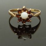 A 9ct gold ring set with an opal and garnets, size P, 1.72g