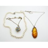 A strand of cultured pearls, a pressed amber pendant, and a 9ct gold pendant filled with opal