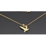 A 14k gold pendant depicting a dove (1.4g) on a 10k gold chain (0.6g)