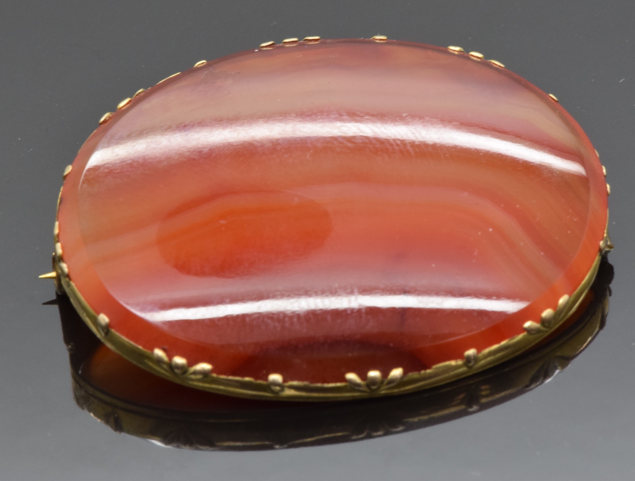 A 9ct gold brooch set with banded agate, 4.2 x 3cm