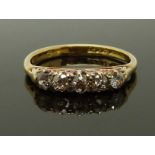 An 18ct gold ring set with five diamonds, size K, 2.55g