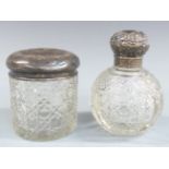 Two cut glass dressing table pots with embossed silver tops, height of taller 11.5cm